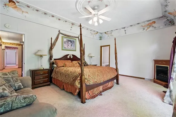 a bedroom with a bed couches and a fireplace