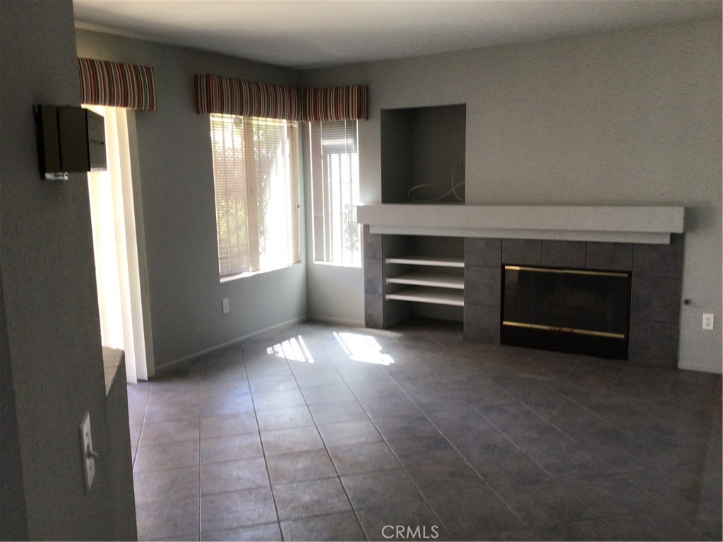 763 Anthirium Avenue Perris, CA 92571 - Photo 4 of 20 a view of an empty room with a fireplace and a window