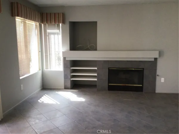 a view of an empty room with a fireplace and a window