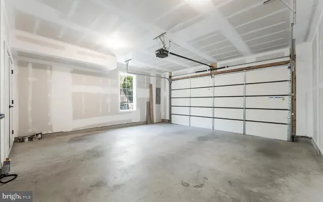 a view of an empty room with wooden floor and stairs