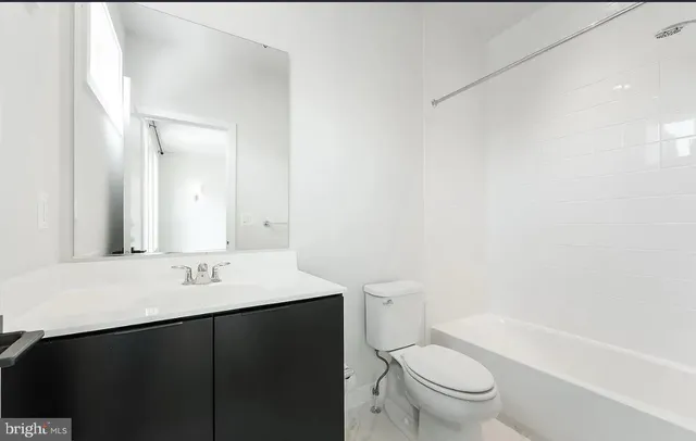 a bathroom with a tub sink shower and mirror