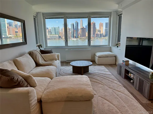 a living room with furniture a flat screen tv and a window