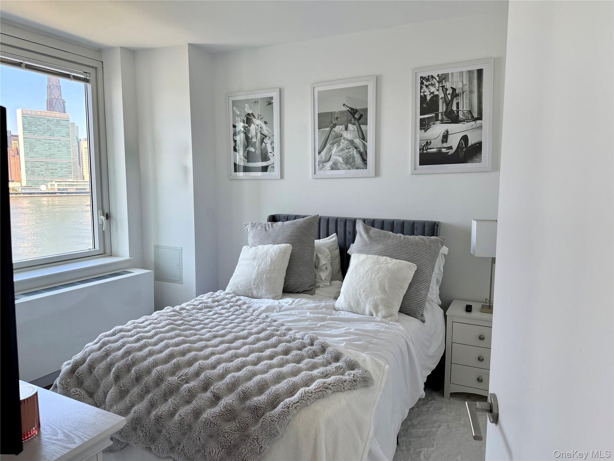 52-03 Center Boulevard, Unit 928 Queens, NY 11101 - Photo 6 of 13 a bedroom with bed and wall painting with wooden floor