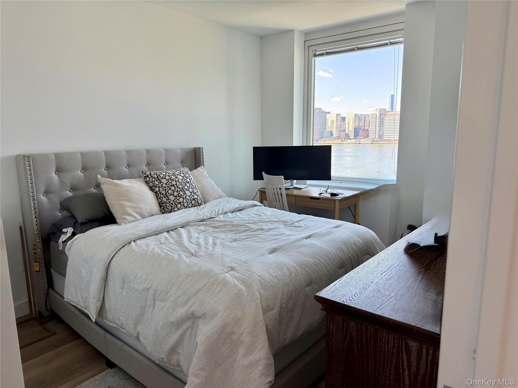 52-03 Center Boulevard, Unit 928 Queens, NY 11101 - Photo 7 of 13 a bedroom with a bed and a table in it