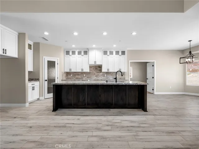 a large kitchen with stainless steel appliances granite countertop a lot of counter space and wooden floor