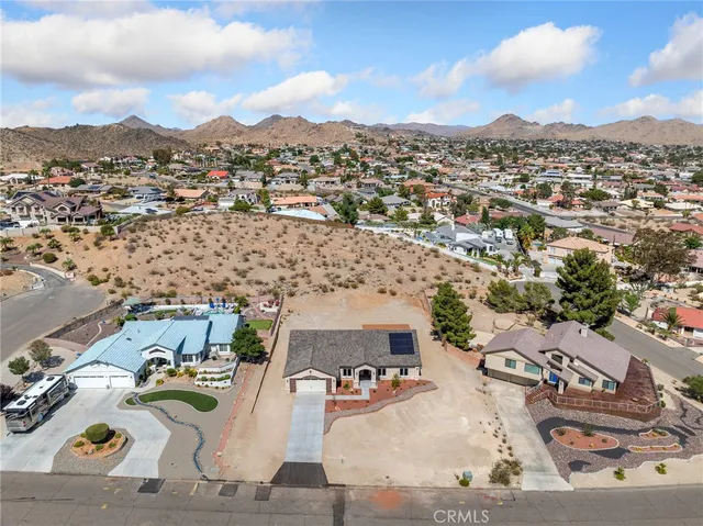 an aerial view of a house with a mountain