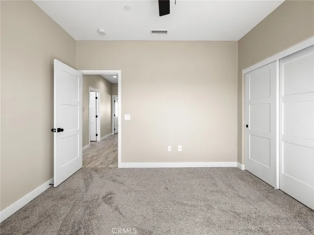 an empty room with a window and a fan