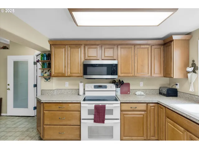 a kitchen with kitchen island granite countertop a sink cabinets and stainless steel appliances