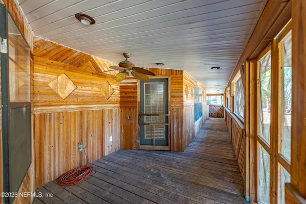 a view of a patio with table and chairs with wooden floor and fence