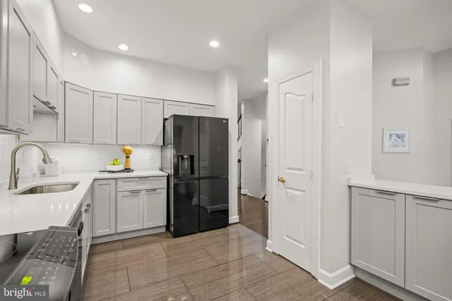 a kitchen with a refrigerator sink and cabinets