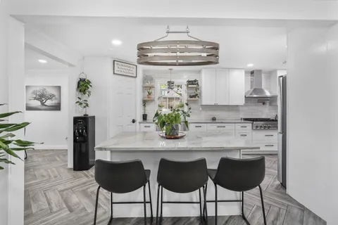 a kitchen with white cabinets and refrigerator