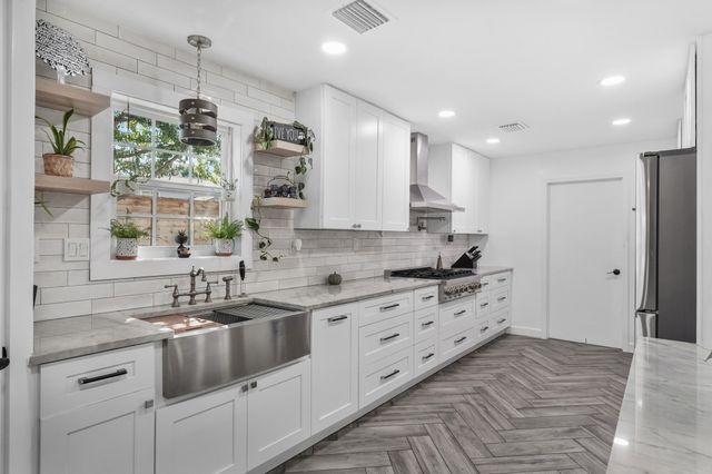 a kitchen with white cabinets and refrigerator