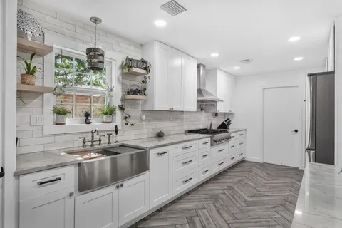 a view of a kitchen with sink and cabinets