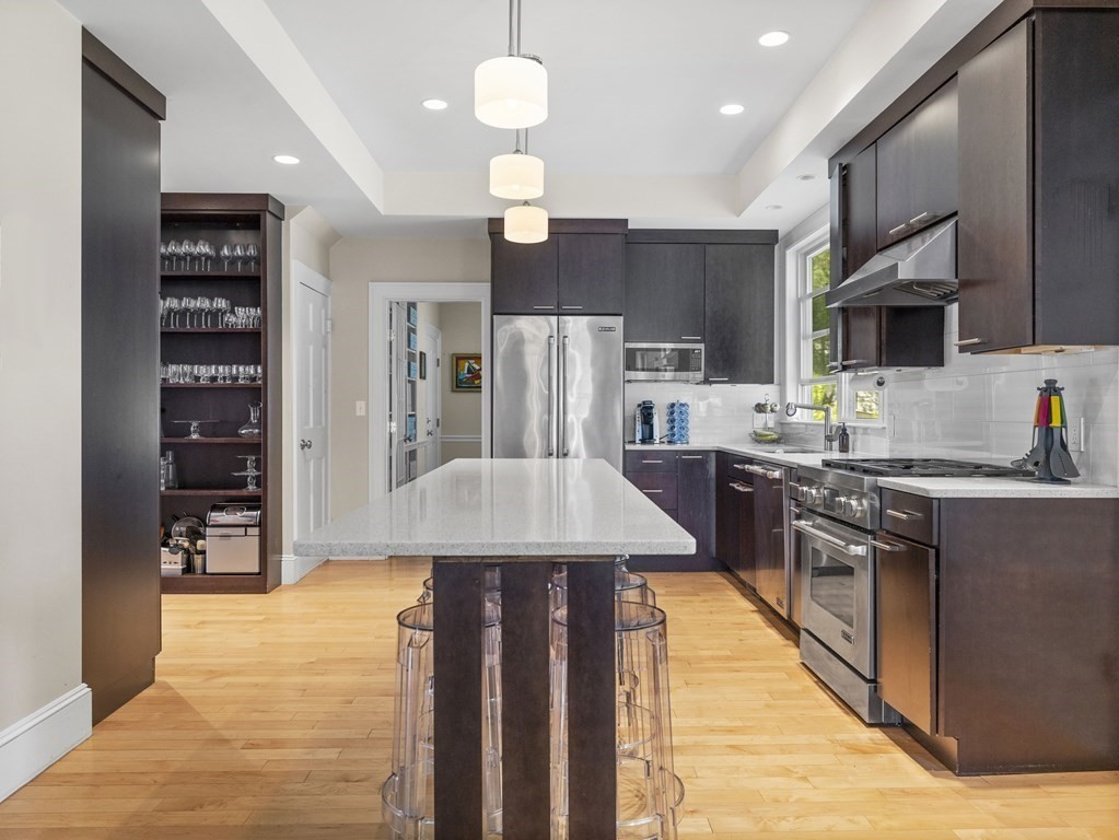 6 Appleby Road Wellesley, MA 02482 - Photo 8 of 21 a kitchen with stainless steel appliances kitchen island granite countertop a table chairs in it and wooden floors