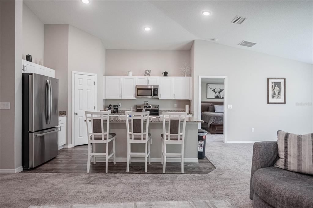 1719 Durden Road Winter Haven, FL 33880 - Photo 19 of 39 a living room with furniture a refrigerator and kitchen view