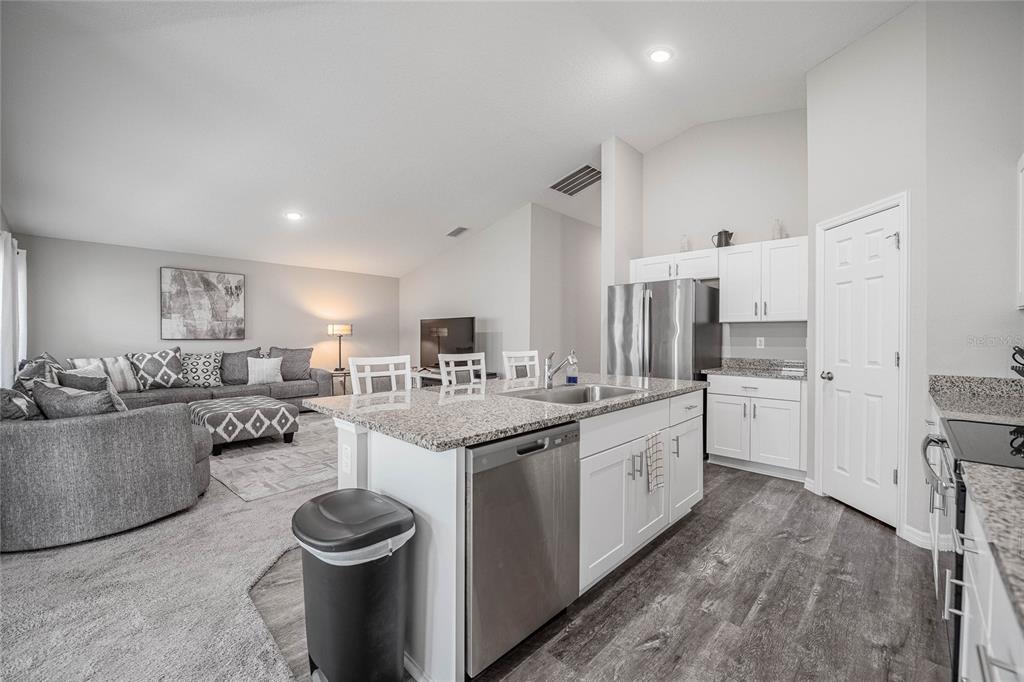 1719 Durden Road Winter Haven, FL 33880 - Photo 22 of 39 a kitchen with stainless steel appliances and white cabinets