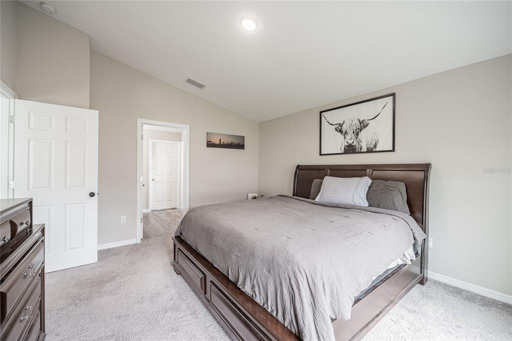 1719 Durden Road Winter Haven, FL 33880 - Photo 29 of 39 a bedroom with bed and paintings on the wall