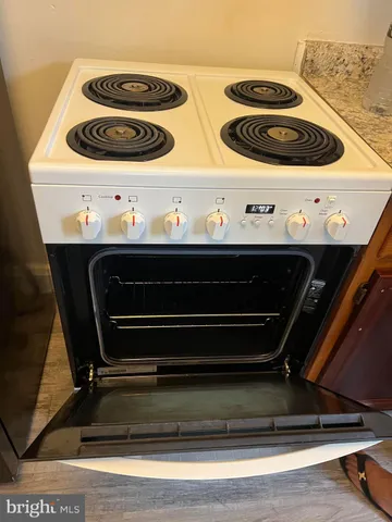 a view of an empty room with wooden floor and stairs