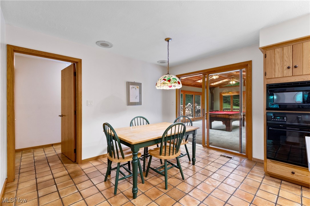7098 Taylor Road Clinton, OH 44216 - Photo 17 of 39 Dining space with light tile patterned floors and billiards