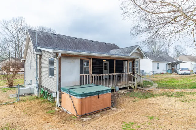 a front view of a house with a yard outdoor seating and a tree