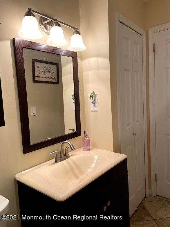 1314 Treeneedle Road Point Pleasant, NJ 08742 - Photo 30 of 62 a bathroom with a sink and a mirror