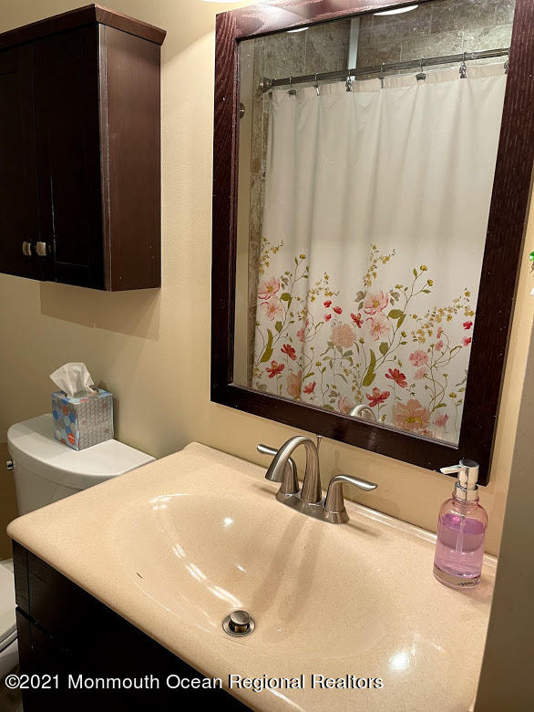 1314 Treeneedle Road Point Pleasant, NJ 08742 - Photo 32 of 62 a bathroom with a tub sink and mirror