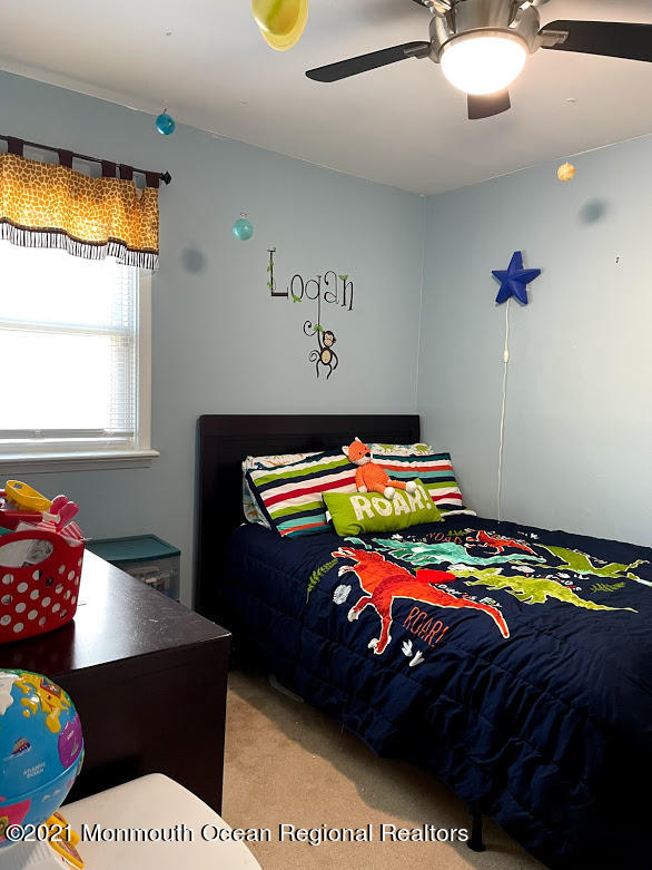 1314 Treeneedle Road Point Pleasant, NJ 08742 - Photo 42 of 62 a bedroom with a bed that has a blanket on it and next to a window