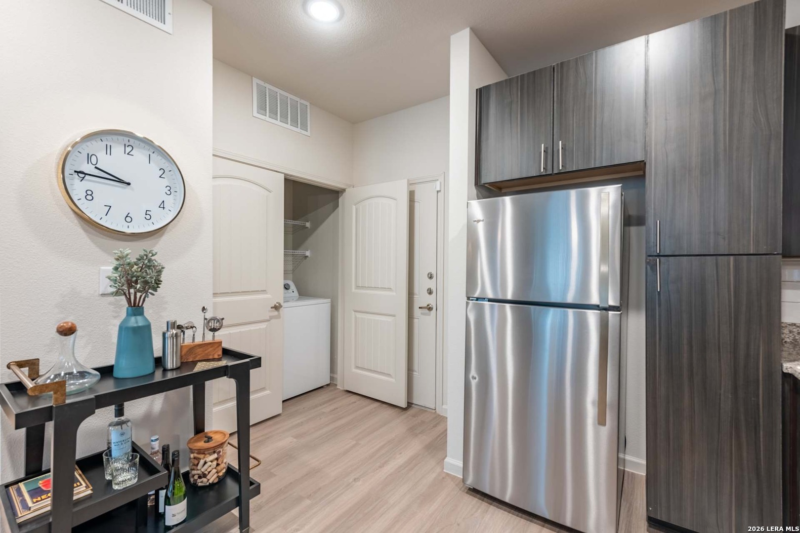 12001 Heatherly, Unit 2202 Austin, TX 78747 - Photo 12 of 15 a kitchen with stainless steel appliances a refrigerator and a clock on the wall