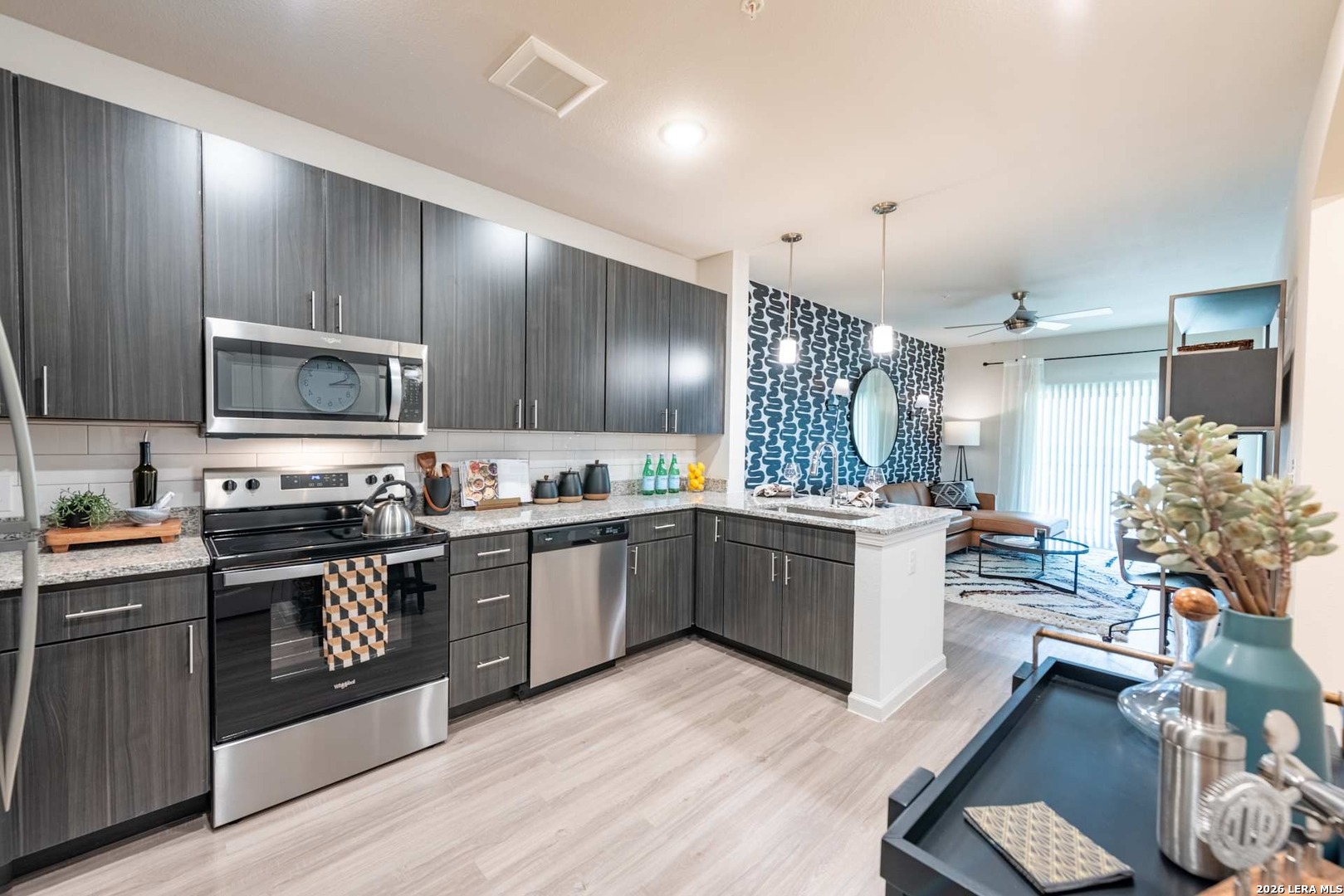 12001 Heatherly, Unit 2202 Austin, TX 78747 - Photo 14 of 15 a large kitchen with cabinets wooden floor and stainless steel appliances