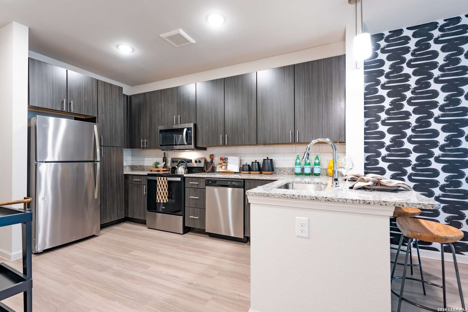 12001 Heatherly, Unit 2202 Austin, TX 78747 - Photo 10 of 15 a kitchen with kitchen island granite countertop stainless steel appliances and wooden cabinets