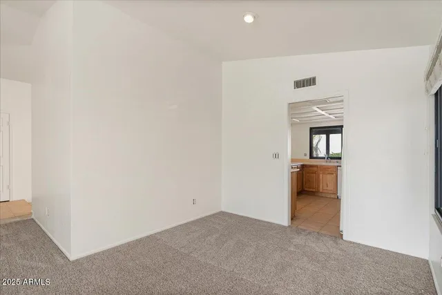 a view of an empty room with cabinet and a window