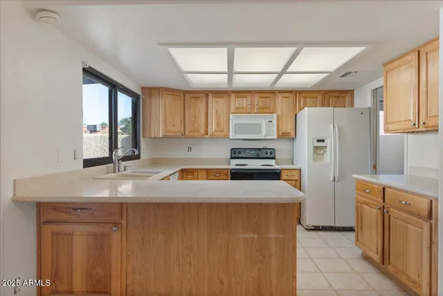 a kitchen with stainless steel appliances granite countertop a refrigerator a sink dishwasher a stove with wooden cabinets and floor