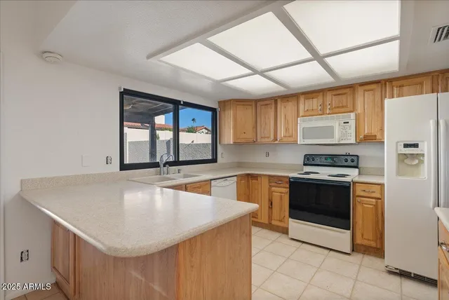 a kitchen with stainless steel appliances granite countertop a sink a stove and a refrigerator