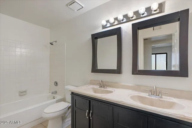 a bathroom with a toilet a sink a bathtub and a mirror