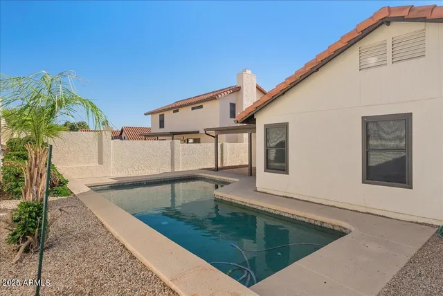 a view of a house with pool and a yard