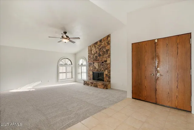 a view of a livingroom with a fireplace and windows