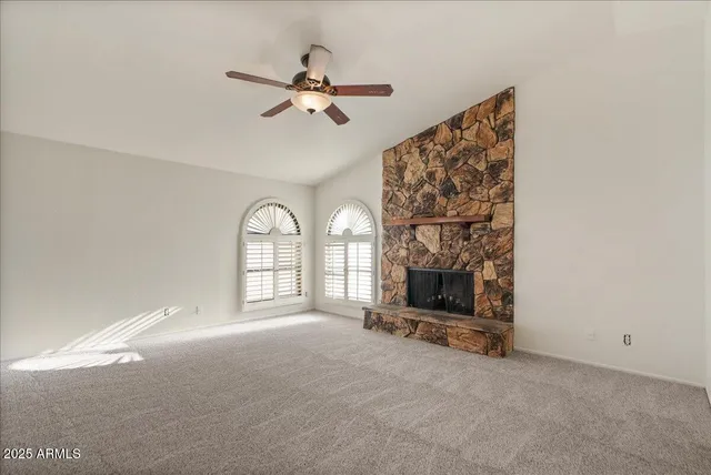 a view of an empty room with a fireplace and a window