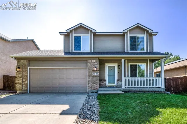 a front view of a house with a garden and garage