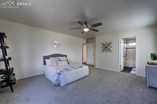 a spacious bedroom with a bed and a chandelier