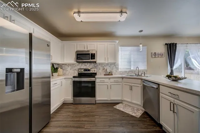 a kitchen with granite countertop a sink stainless steel appliances and cabinets