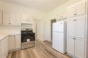 a kitchen with stainless steel appliances granite countertop white cabinets and a stove top oven