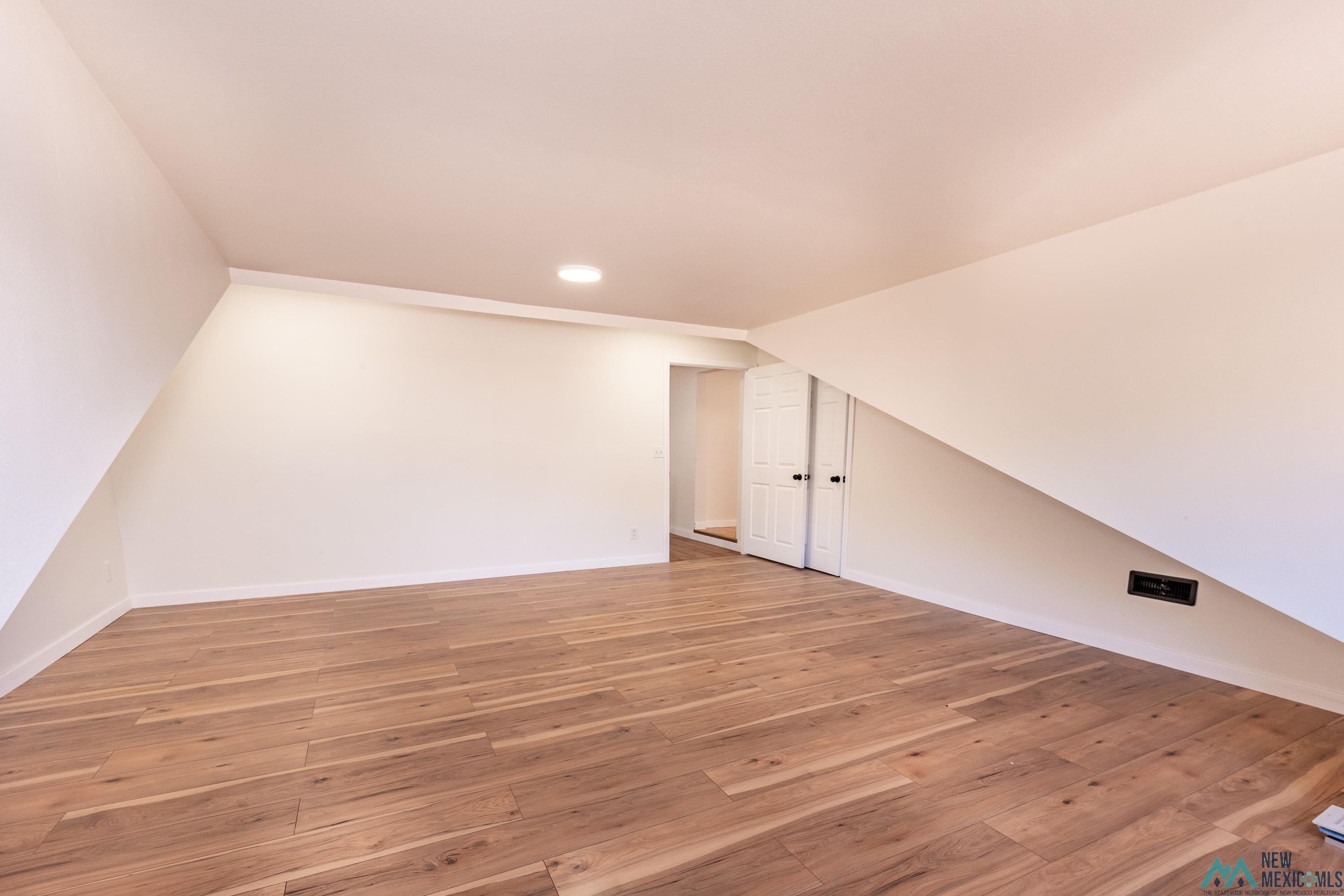 1131 Lincoln Avenue Raton, NM 87740 - Photo 13 of 41 Bonus room with light wood-type flooring, lofted ceiling, and recessed lighting