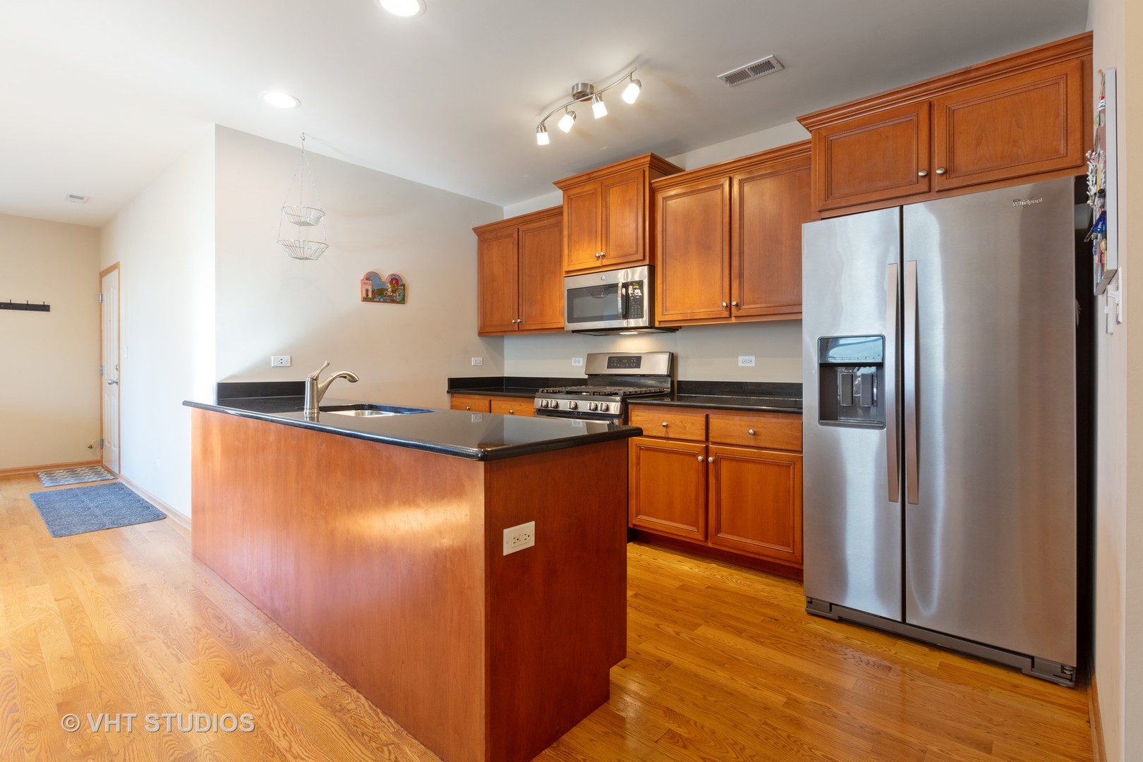 1429 West Fillmore Street, Unit 2 Chicago, IL 60607 - Photo 6 of 14 a kitchen with stainless steel appliances granite countertop a refrigerator a stove a sink and a microwave