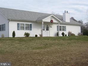 63 Elm Drive Colonial Beach, VA 22443 - Photo 7 of 7 a view of a white house with a yard