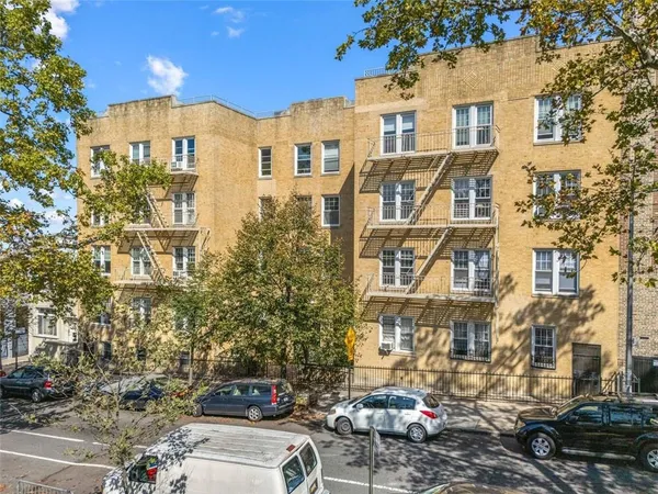 a front view of a residential apartment building with a yard
