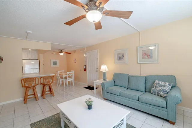 a living room with furniture a chandelier and a dining table