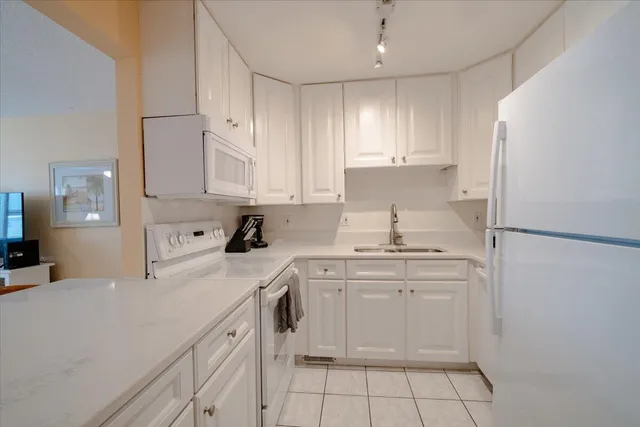 a kitchen with white cabinets stainless steel appliances and sink