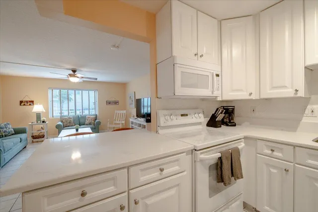 a kitchen with white cabinets and white appliances