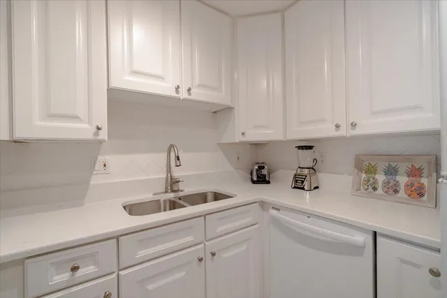a kitchen with white cabinets and a sink