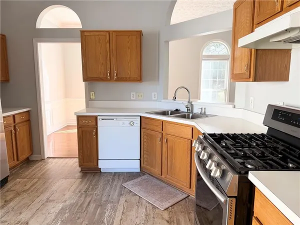 a kitchen with sink a stove and cabinets